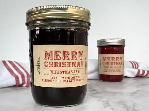 Two mason jars filled with jam and jelly with Custom Merry Christmas canning labels wrapping around them. One jar is filled with Christmas Jam and the other has Holly Jolly Jelly. | CanningCrafts.com