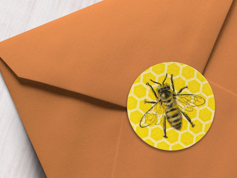 Round printed yellow honey bee labels with honeycomb pattern on an orange envelope | CanningCrafts.com